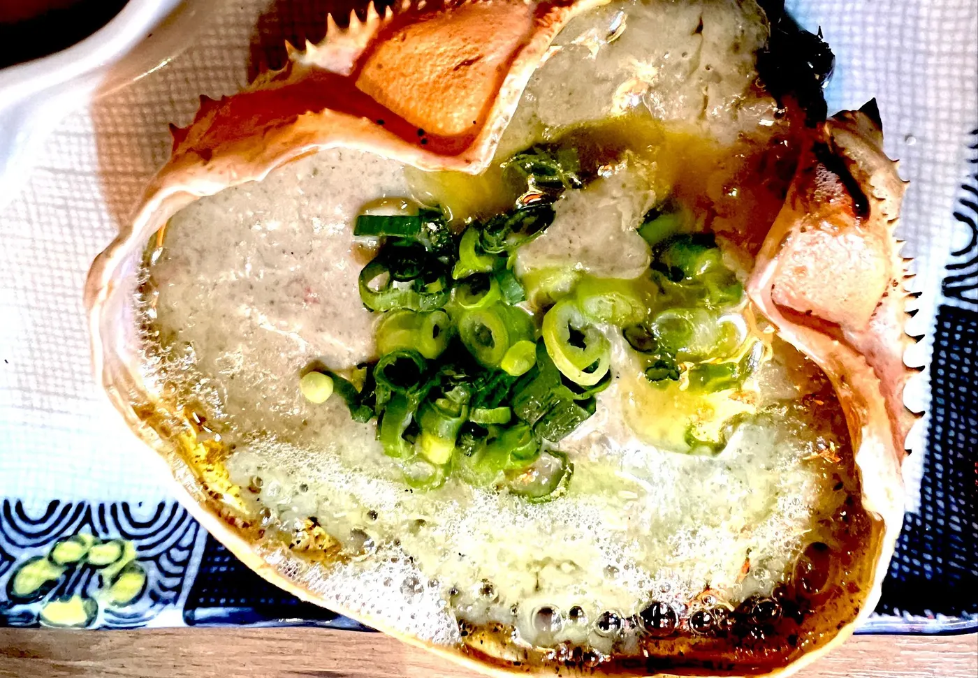 青ネギを載せた蟹味噌甲羅焼き